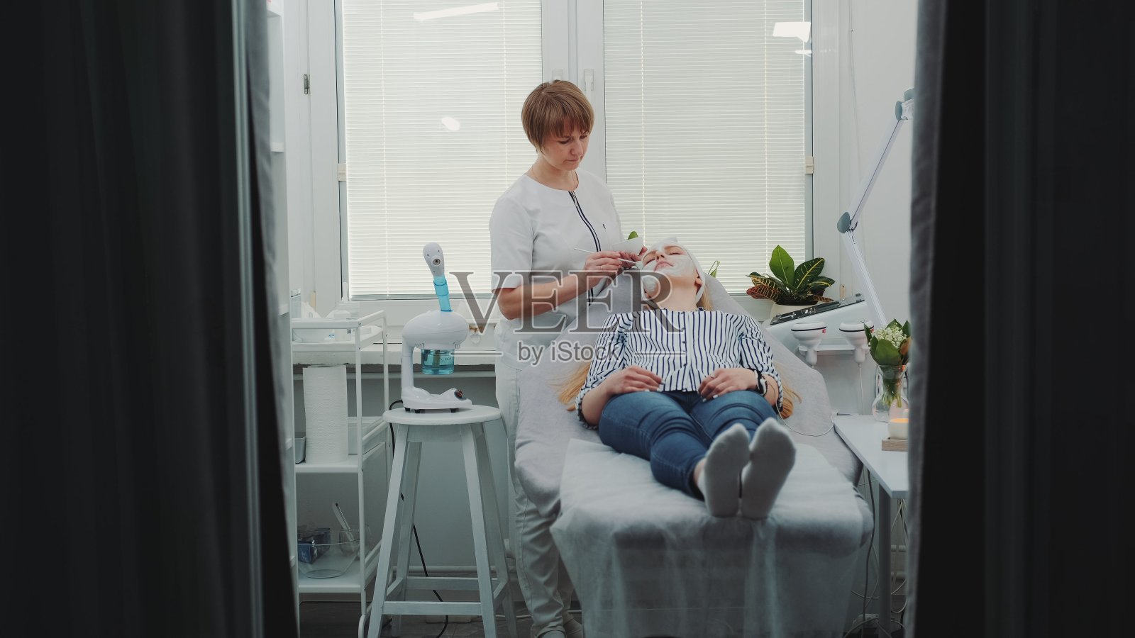 美容师在美容院给美女敷面膜照片摄影图片