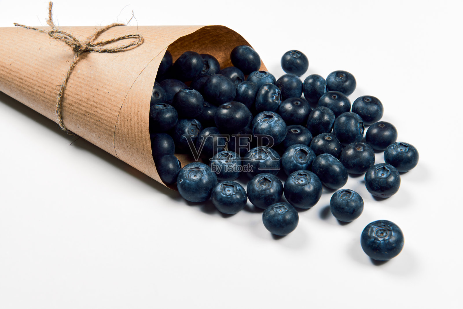 新鲜多汁的pickedÂ blueberriesÂ inÂ工艺纸袋孤立在白色背景。前视图。有选择性的重点。副本的空间。健康饮食和营养的概念。照片摄影图片