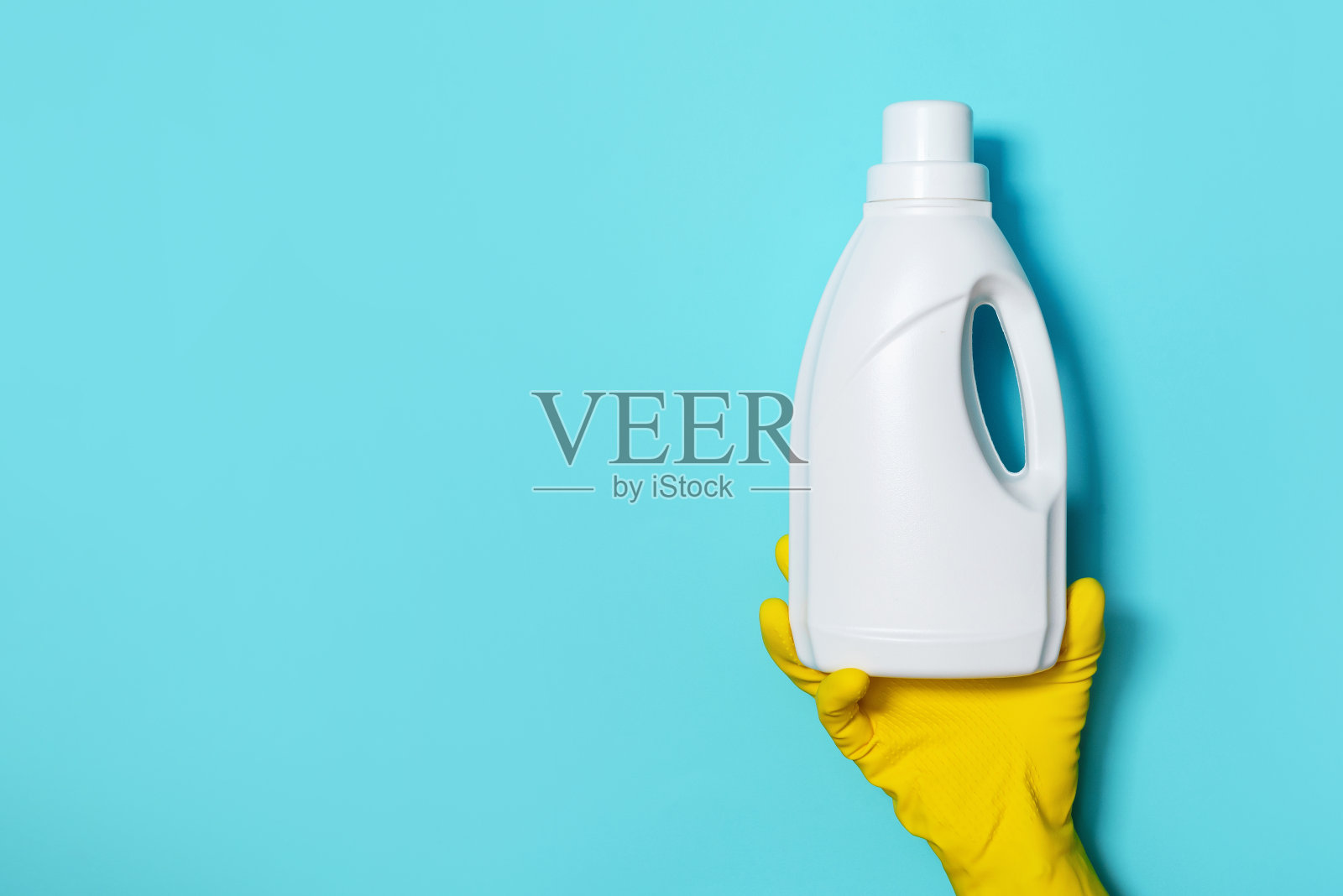 手持手套的白色塑料瓶的清洁产品，家用化学品。副本的空间。清洁服务理念。家用化学清洁用品、刷子及用品。洗涤剂瓶照片摄影图片