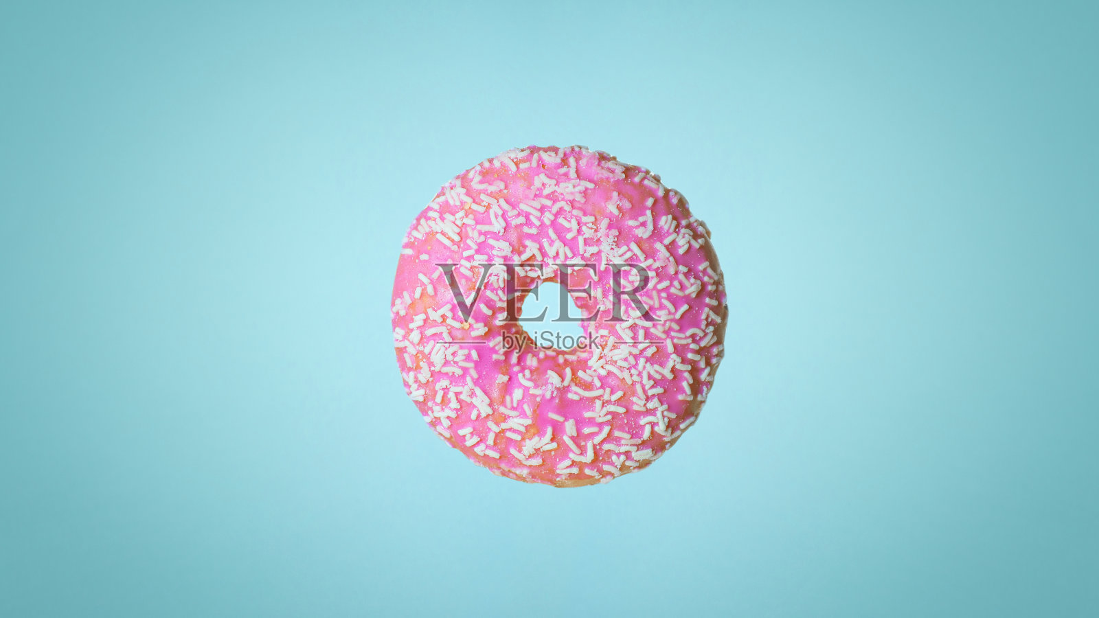 蓝色背景上的粉色甜甜圈。节日和糖果，儿童烘焙，糖的概念照片摄影图片