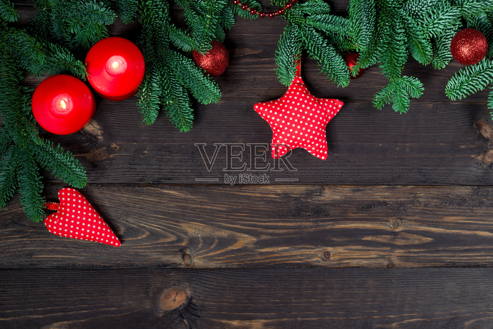 在木板上插上一对蜡烛和冷杉枝，中间放置圣诞贺卡照片摄影图片