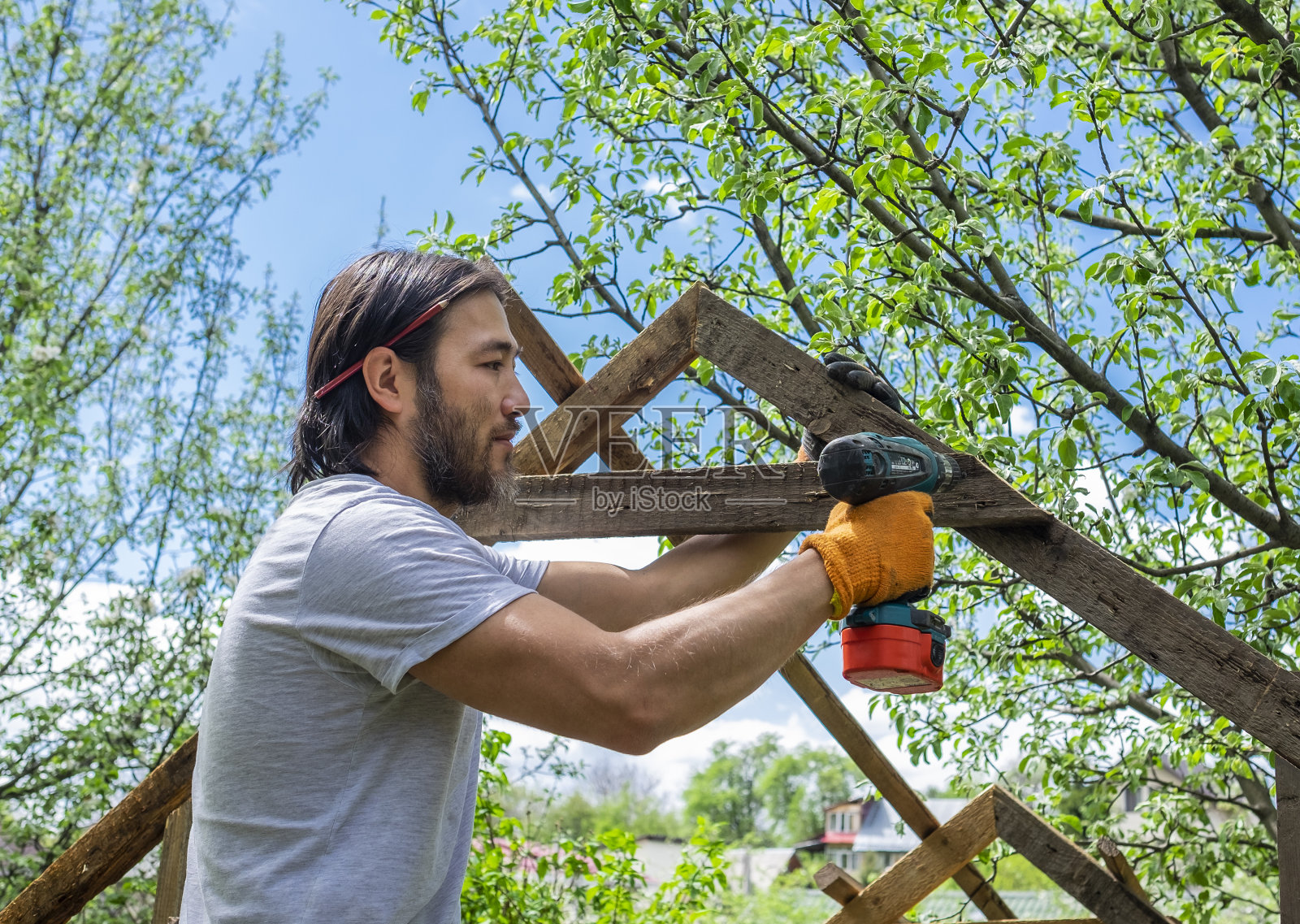 人用电动螺丝刀做木屋顶照片摄影图片