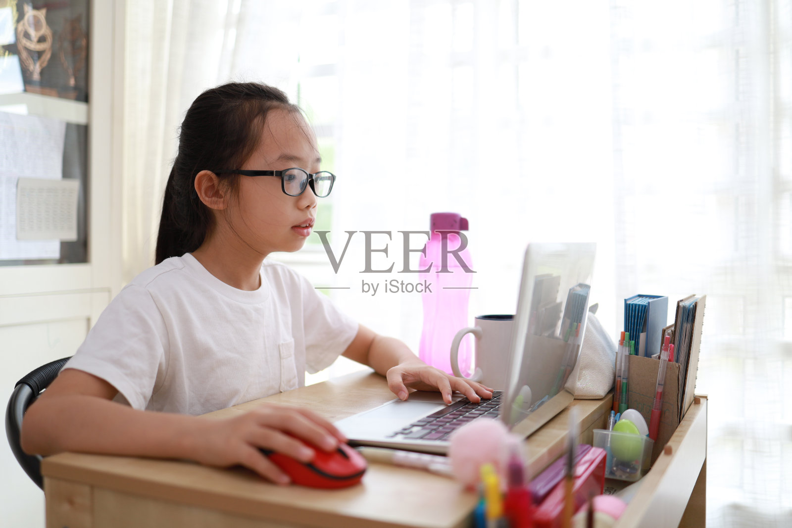 年轻女孩坐在电脑前照片摄影图片