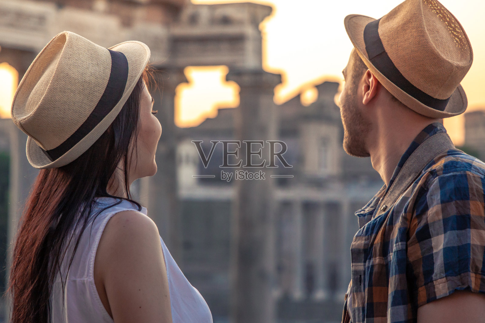 年轻的一对游客看着罗马广场在日出拥抱。历史上的罗马帝国在罗马，意大利全景的观点。照片摄影图片