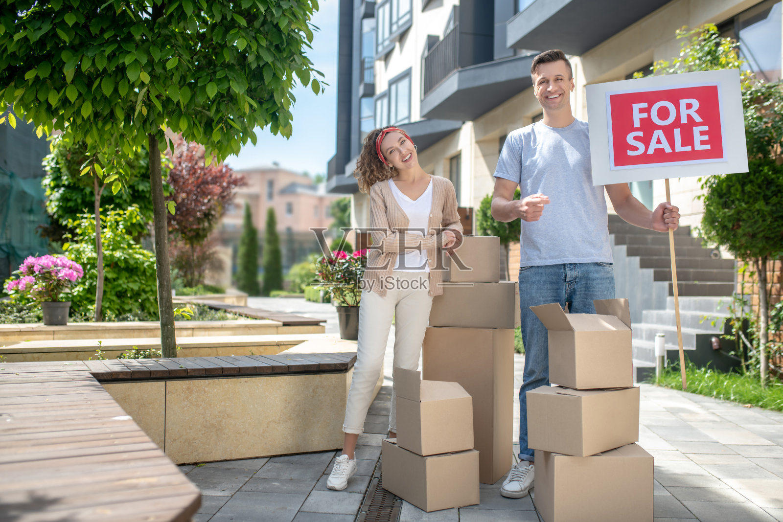一对幸福的夫妇站在纸板旁准备搬到一个新公寓照片摄影图片