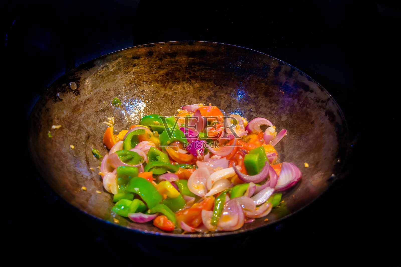 炒锅里炒五颜六色的蔬菜，健康的食物。美味健康素食的概念。近距离照片摄影图片