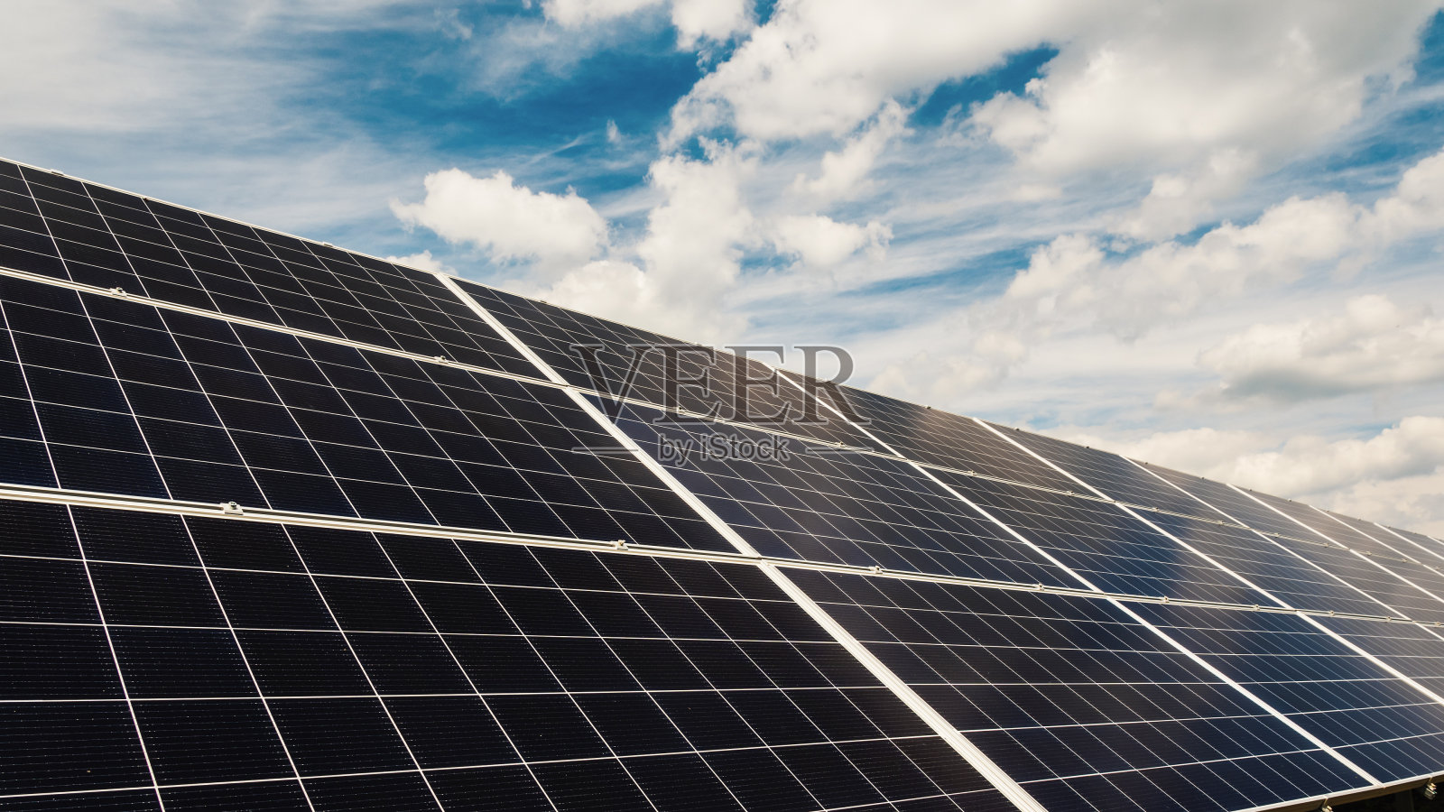 云朵快速漂浮在太阳能发电厂的电池板上照片摄影图片