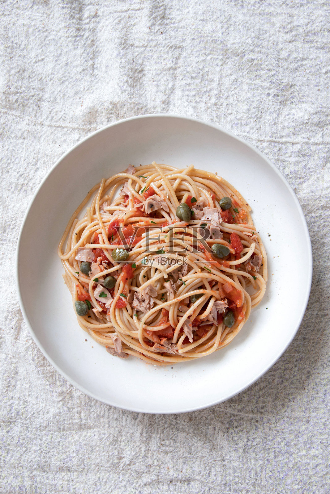 全麦传统意大利面(意大利面)配金枪鱼，酸豆和番茄酱。照片摄影图片