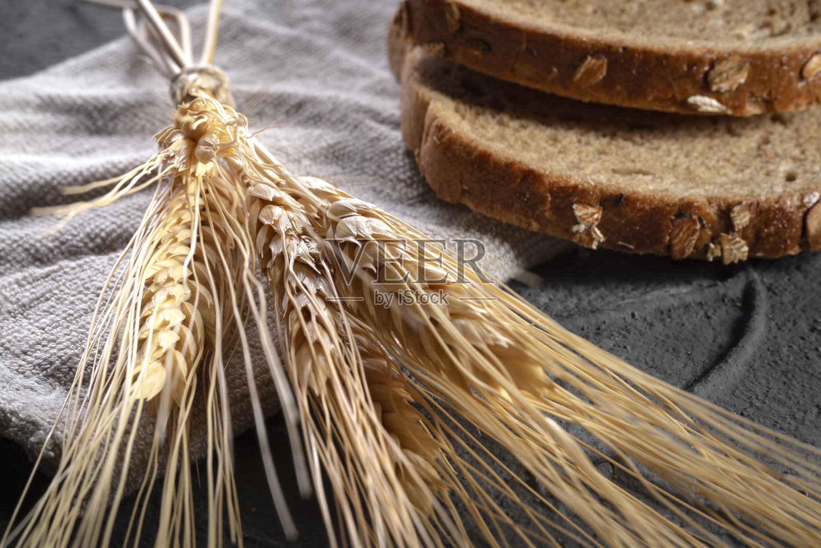 石头背景上的谷物和面包概念照片摄影图片