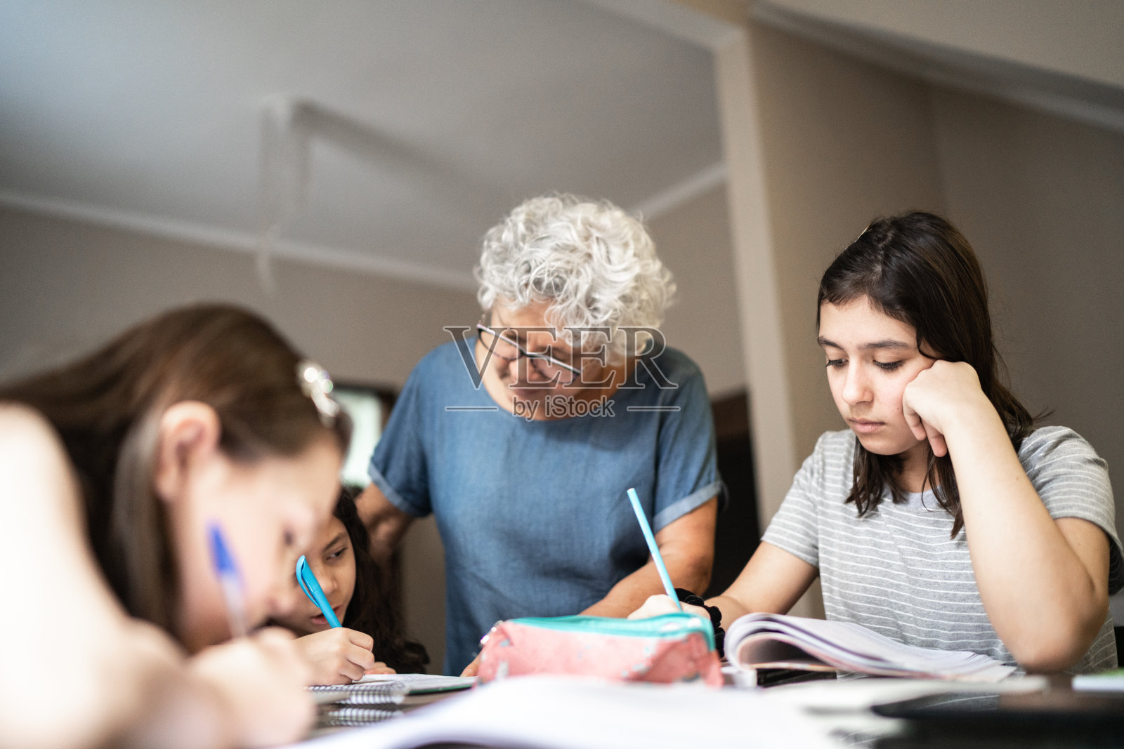 奶奶在孙女在家学习的时候帮她做作业照片摄影图片