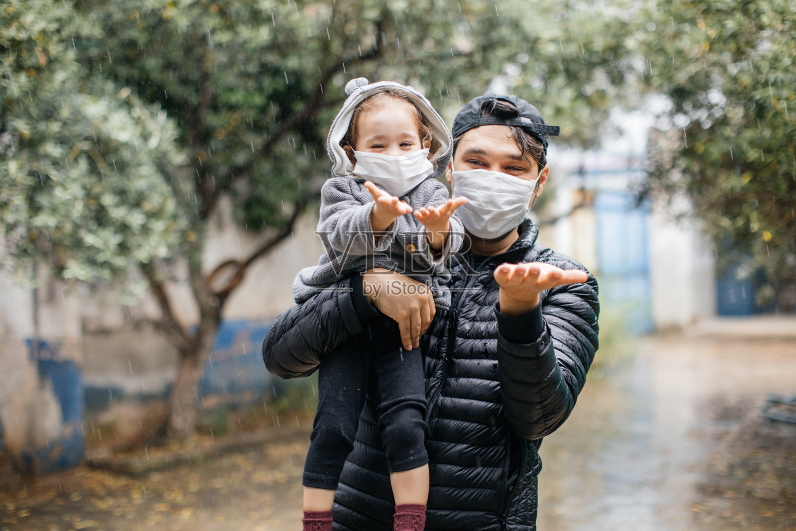 可爱的小女孩和爸爸在户外戴着防护面具微笑照片摄影图片