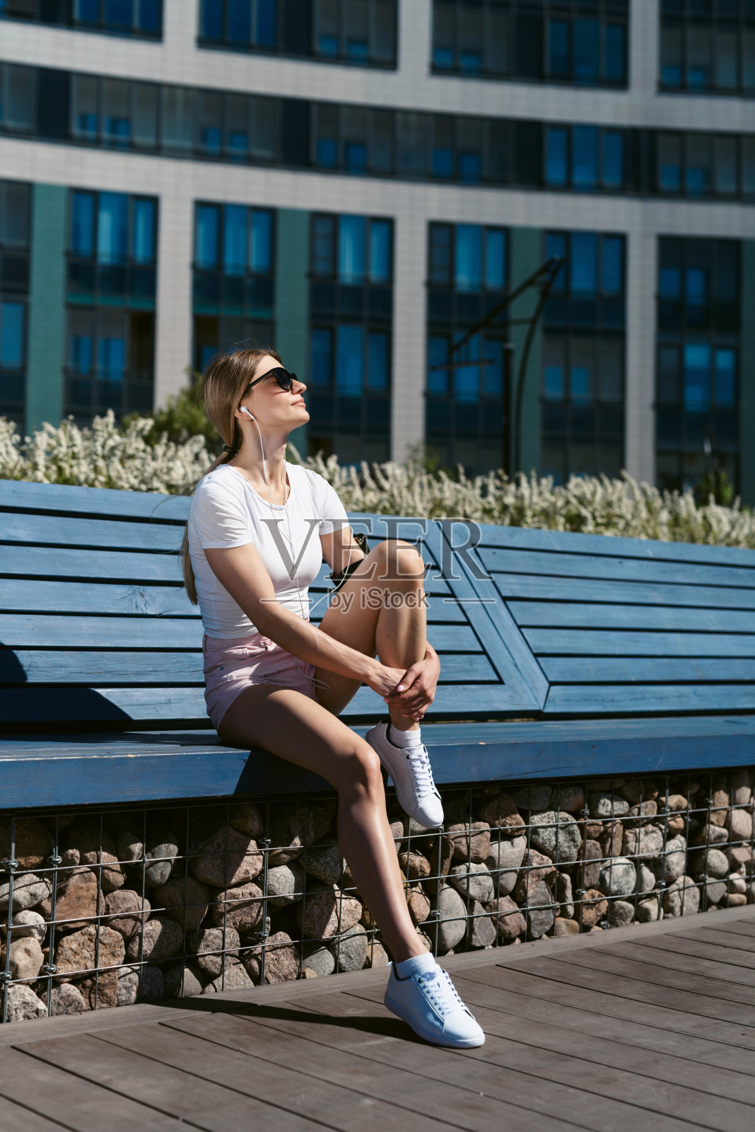 一名年轻的健身妇女在艰难的街头锻炼后休息。健康的生活方式和运动，街头训练，保持社交距离照片摄影图片