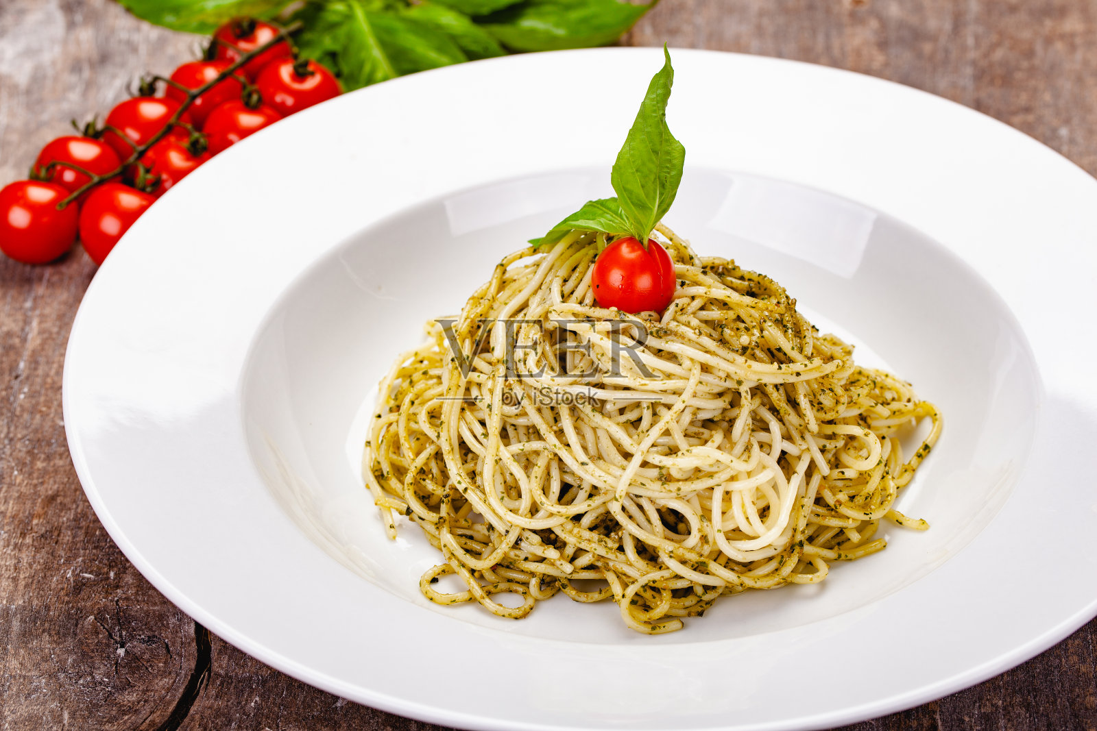 白盘子上放自制香蒜酱的意大利通心粉。近距离照片摄影图片