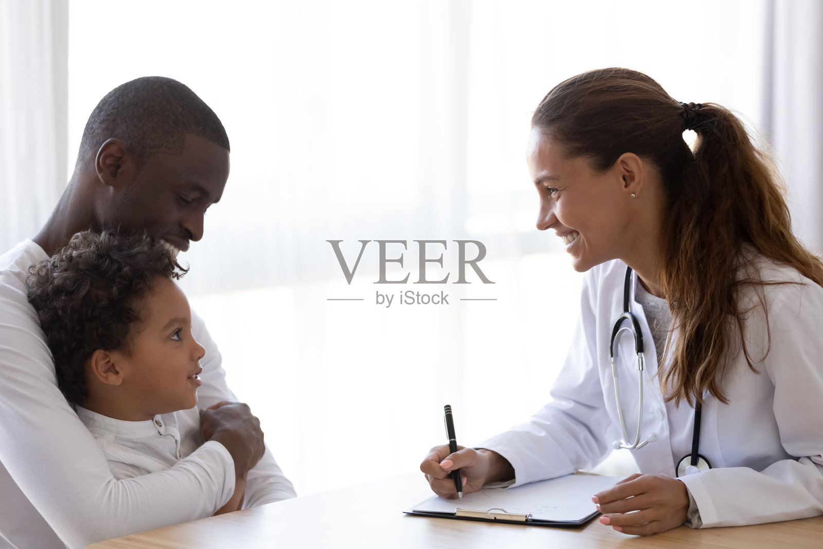 微笑的儿科医生在会议上与非裔美国儿童交谈照片摄影图片