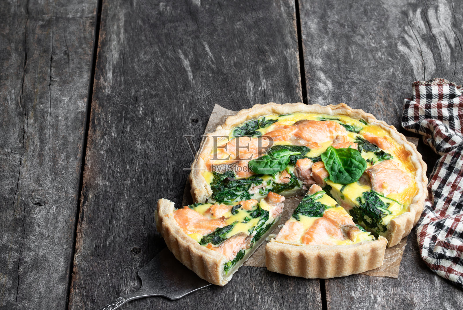粗犷的木桌上放着鲑鱼和菠菜乳蛋饼照片摄影图片