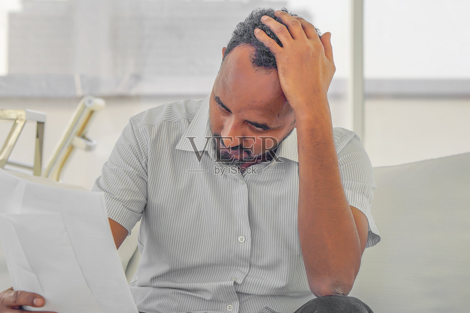 非洲男人在家中阅读坏消息，担心破产照片摄影图片