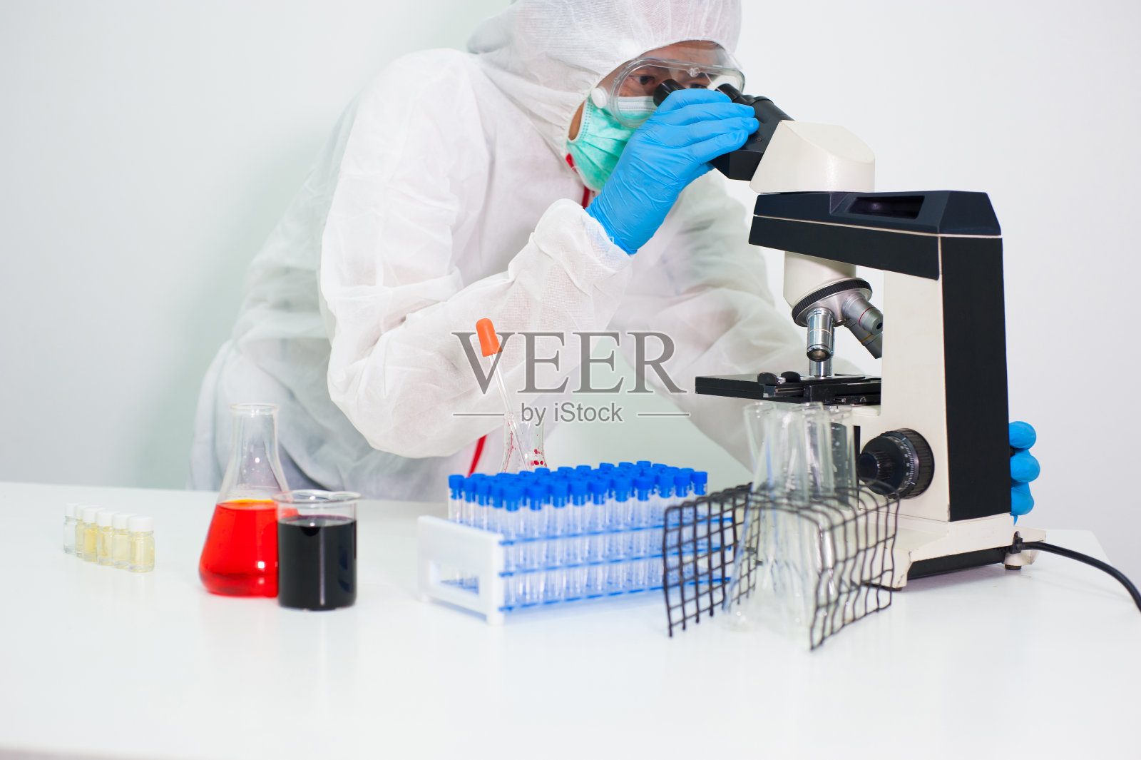 科学家们在实验室里通过显微镜进行研究。照片摄影图片