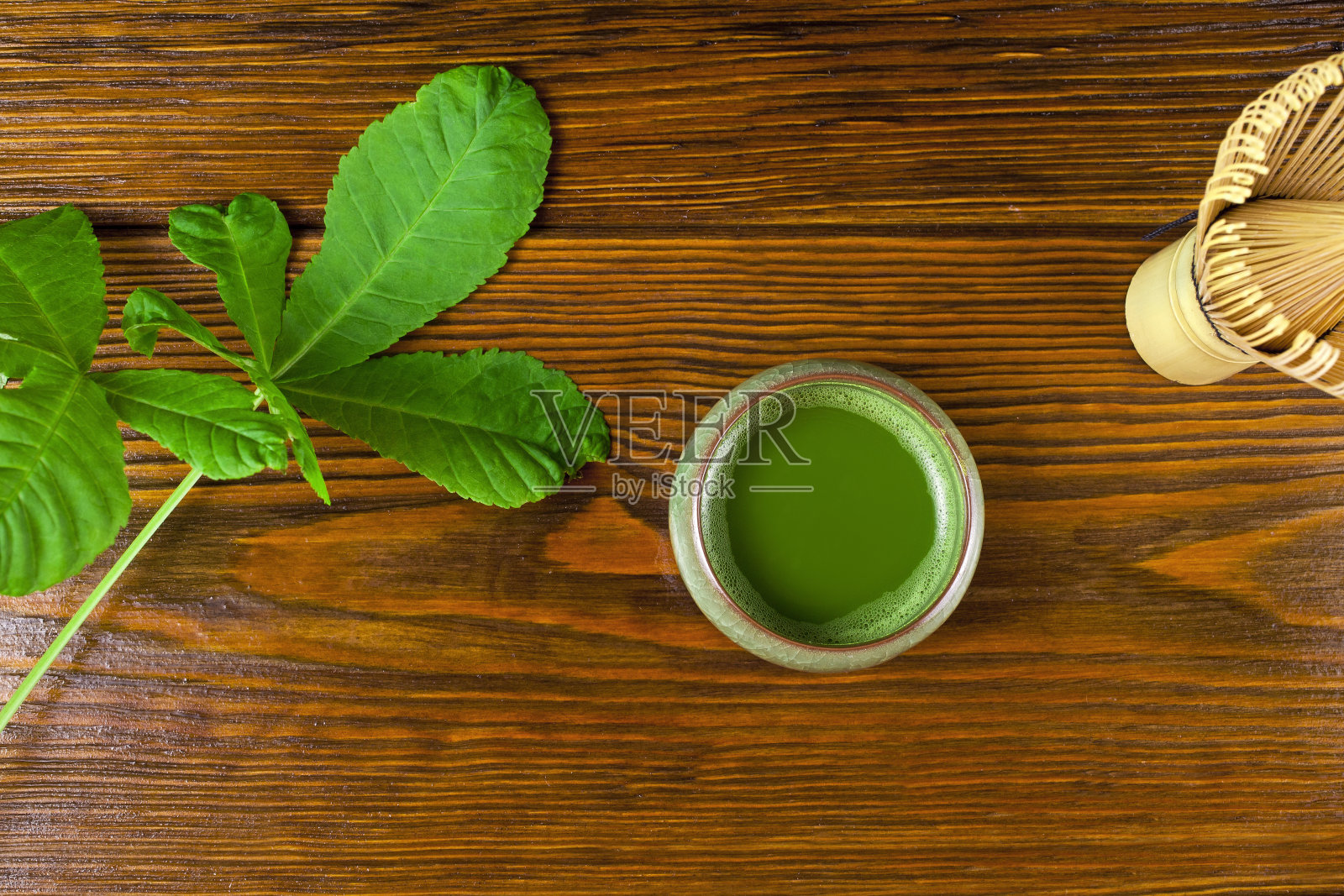 绿茶抹茶，加茶搅拌器和绿叶照片摄影图片