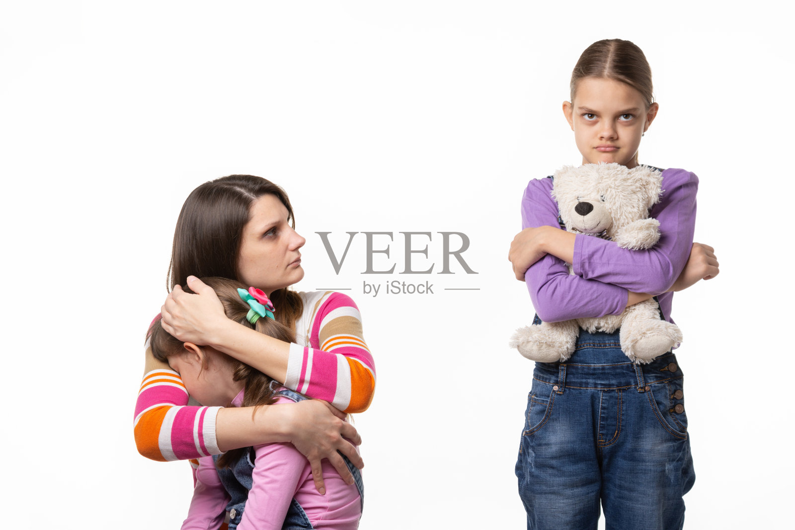 妈妈责备地看着大女儿，因为她冒犯了小女儿照片摄影图片