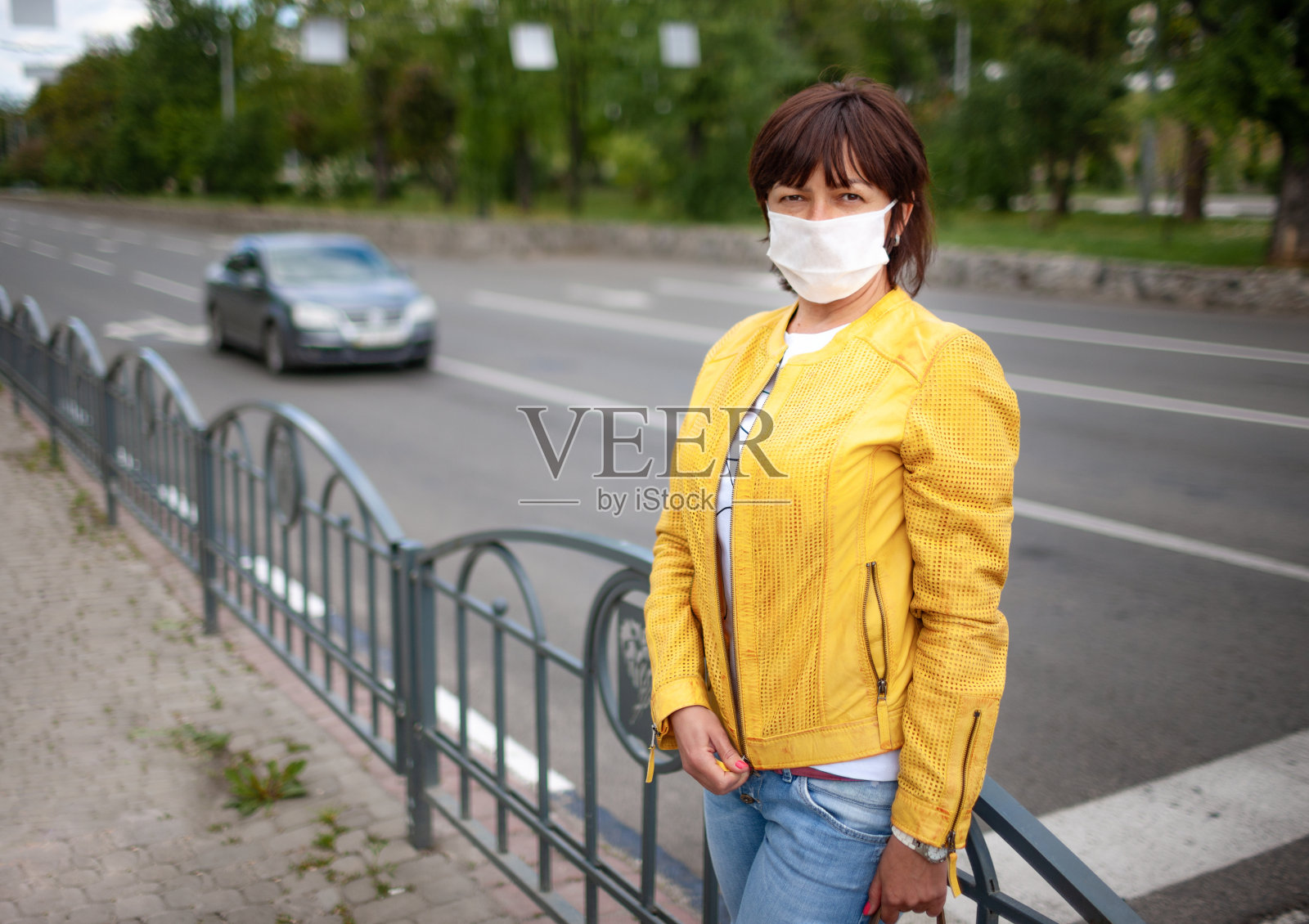 成年漂亮女人在休闲的衣服和包与保护面具照片摄影图片