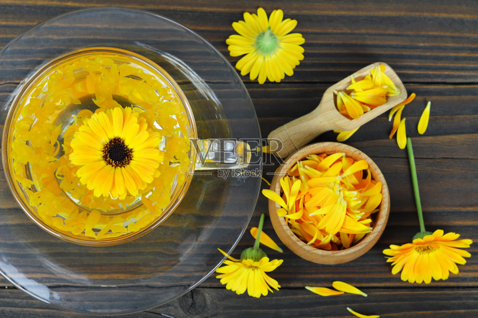 金盏花茶在透明的杯子在木制的背景照片摄影图片