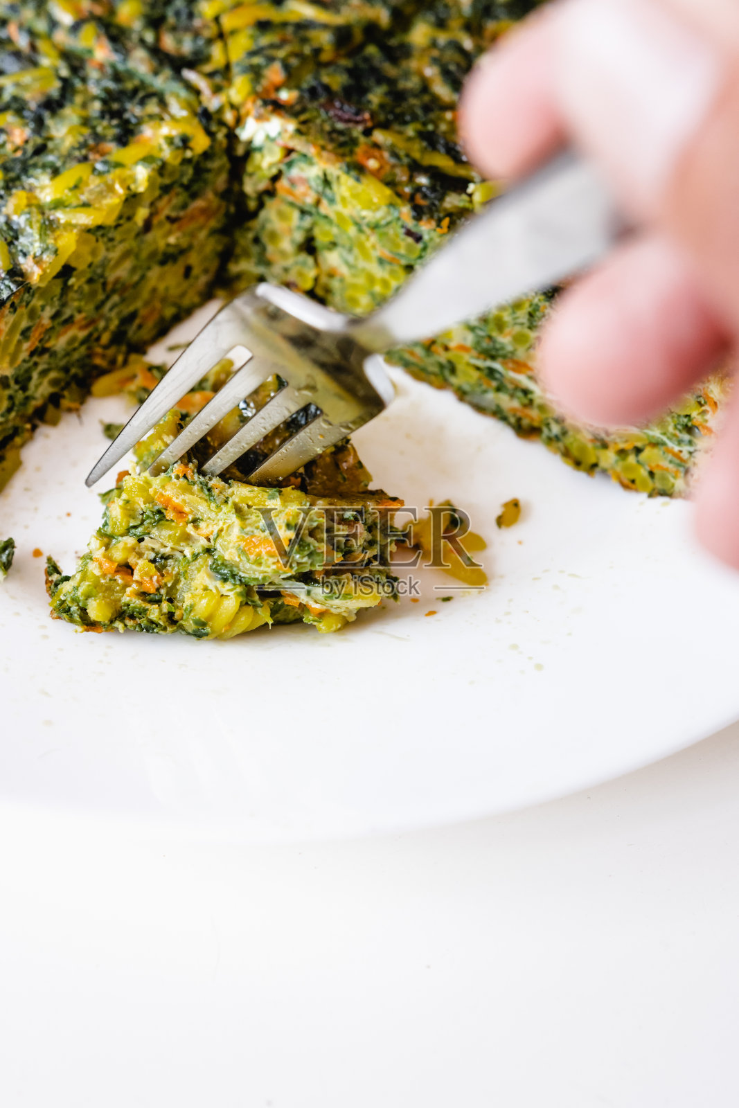 这是叉子的特写镜头，上面放着一块米饭和蔬菜煎蛋卷。照片摄影图片