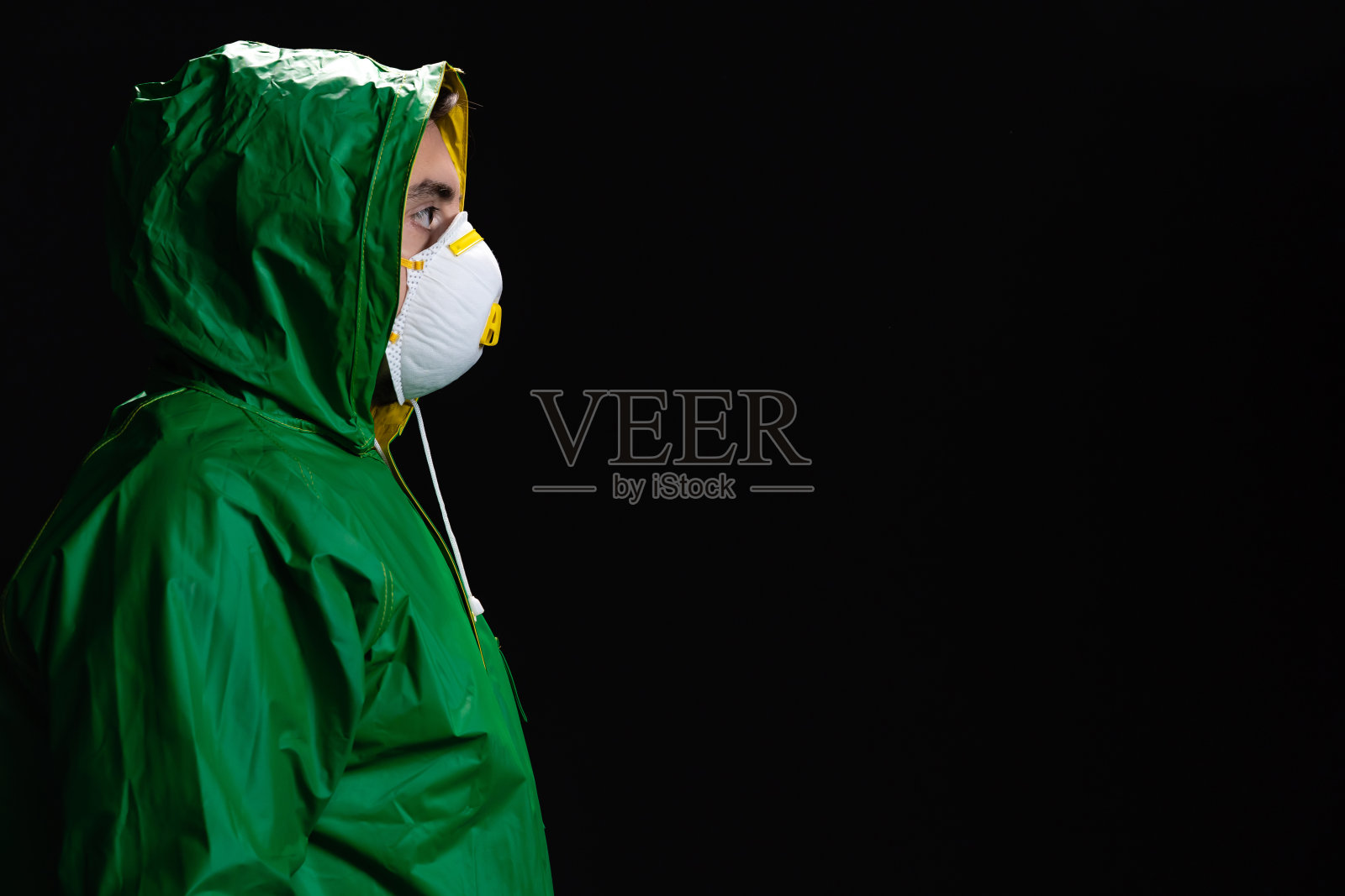 年轻工程师或工人的肖像，拿着他的头盔在黑色的背景照片摄影图片