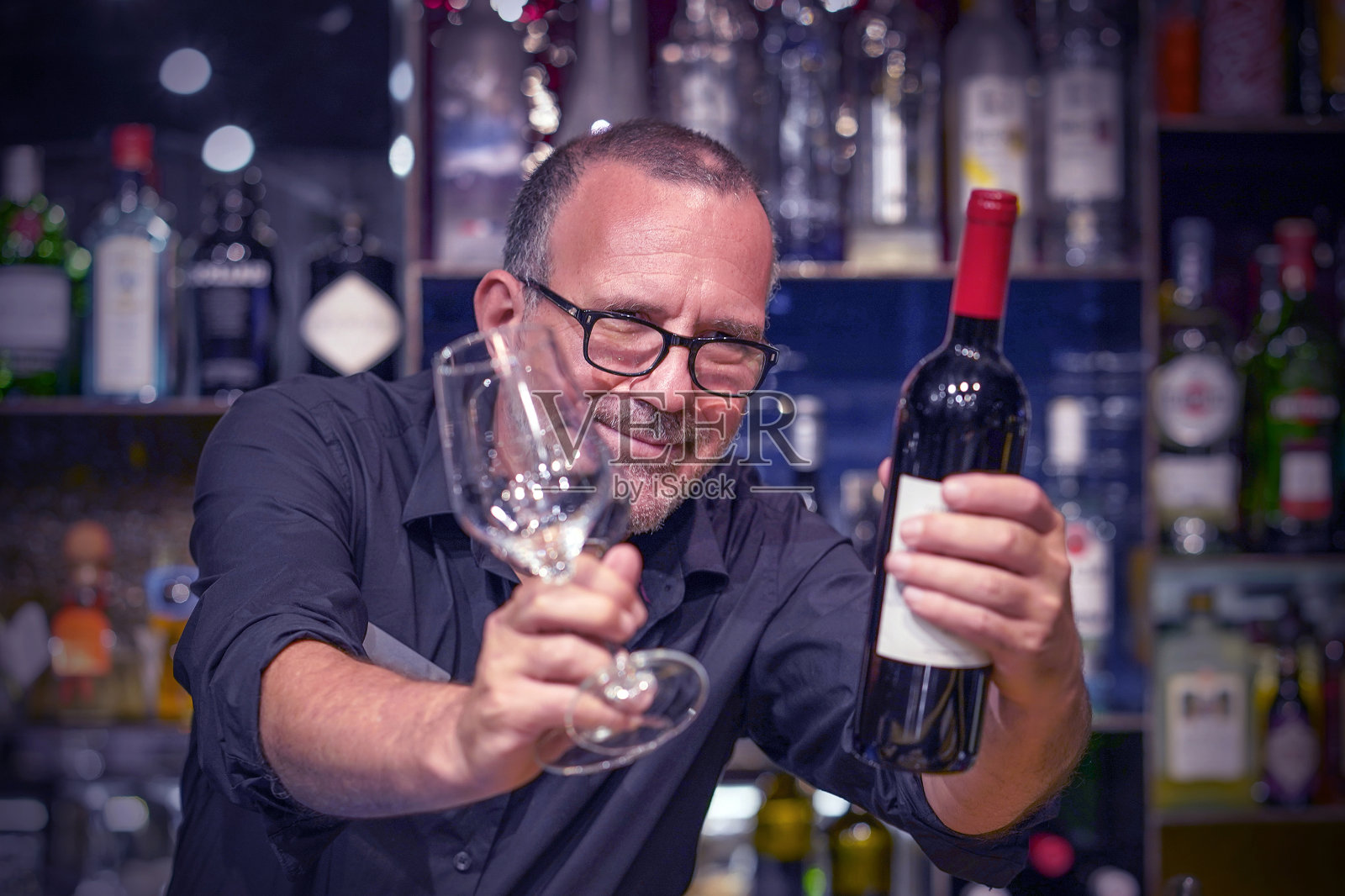 年长的男性酒保递上一杯红酒照片摄影图片