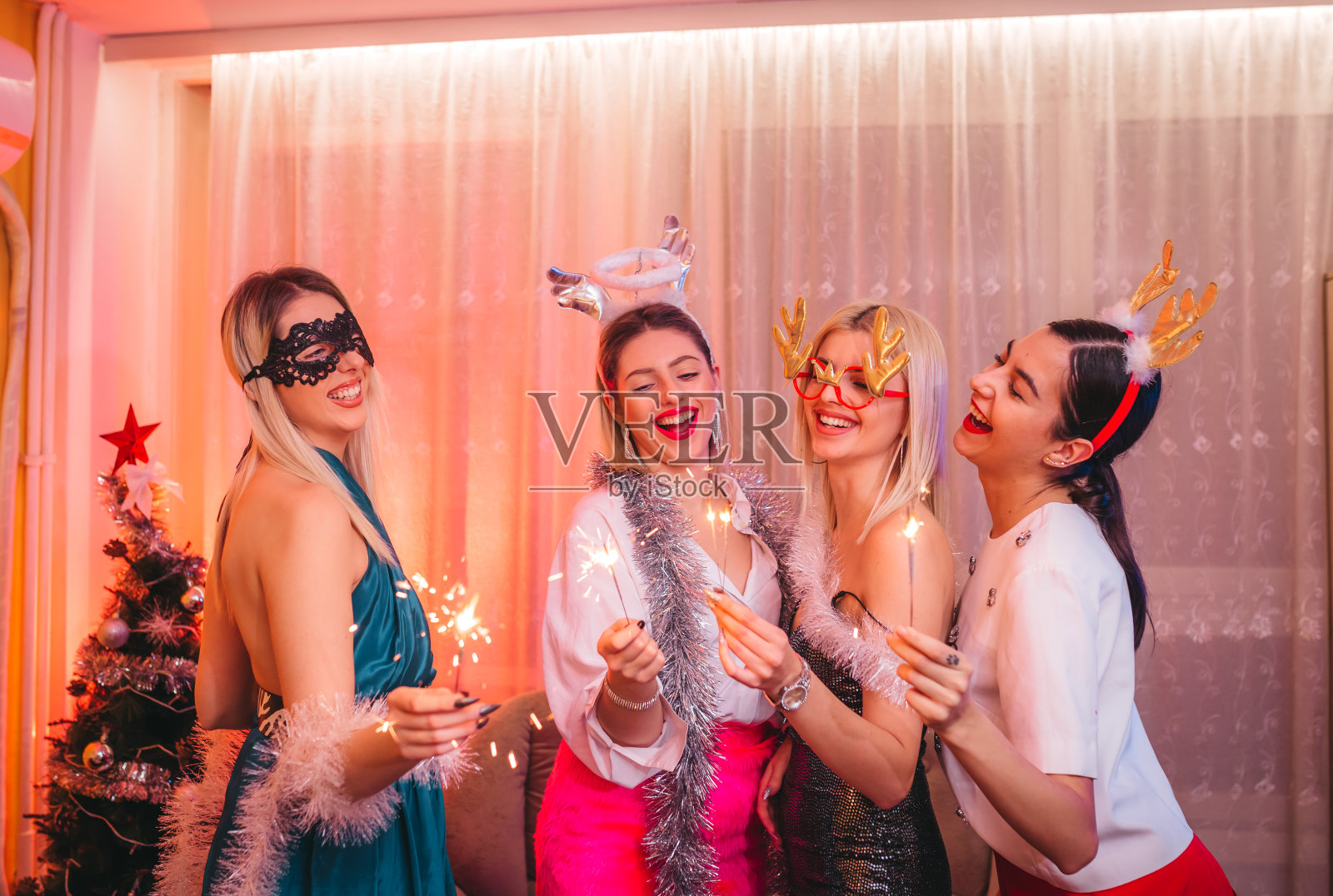 朋友们在室内举行圣诞节洒水喷头照片摄影图片