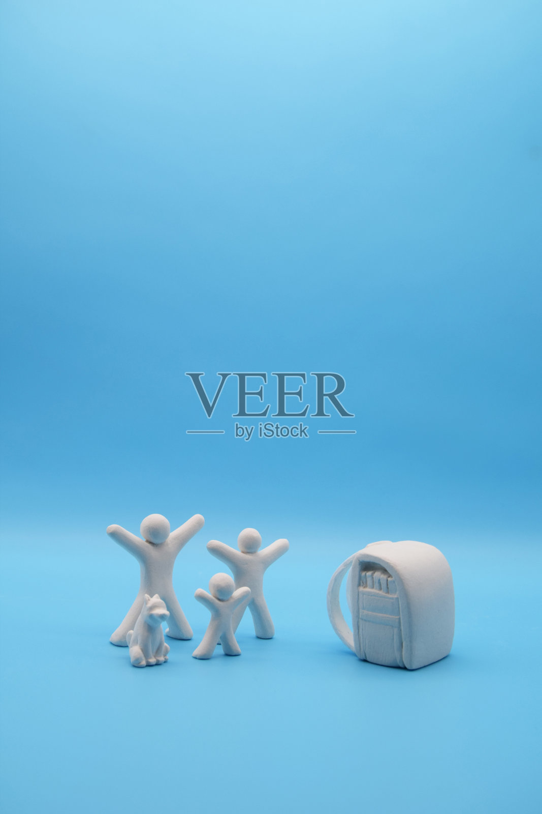 概念形象泥娃娃代表一个家庭，孩子，父亲，母亲，狗，包在蓝色背景。白色的快乐娃娃，简单的风格。照片摄影图片