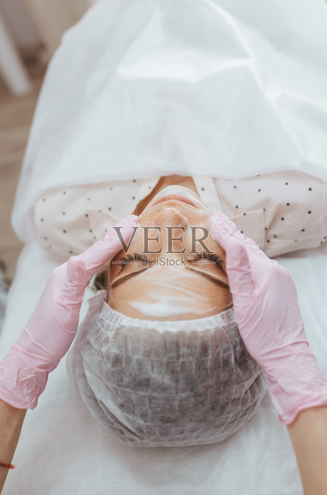 美容师清洗病人脸上的海藻酸盐面膜照片摄影图片