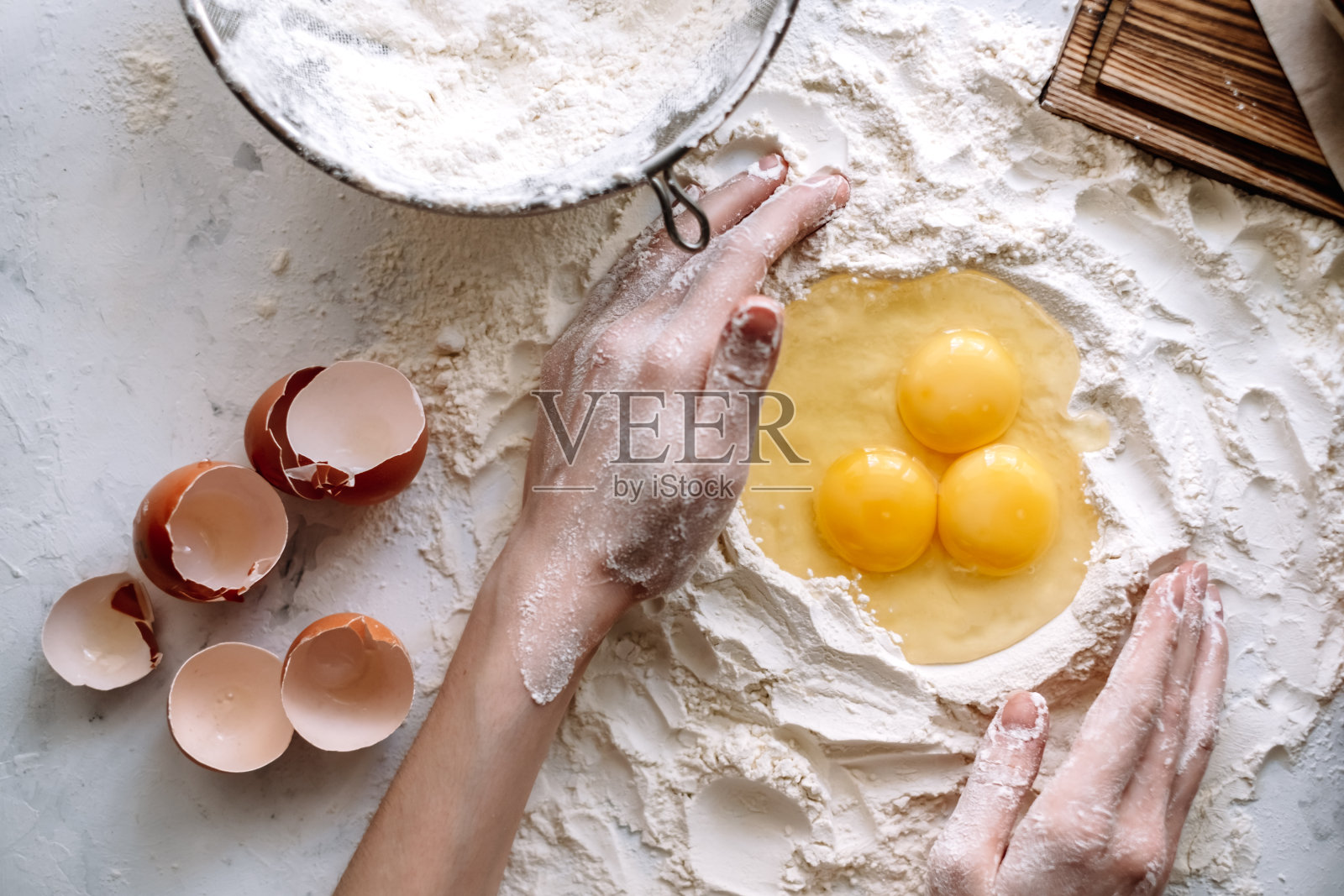 女人煮的面团。面粉鸡蛋放在厨房的桌子上，配料。照片摄影图片