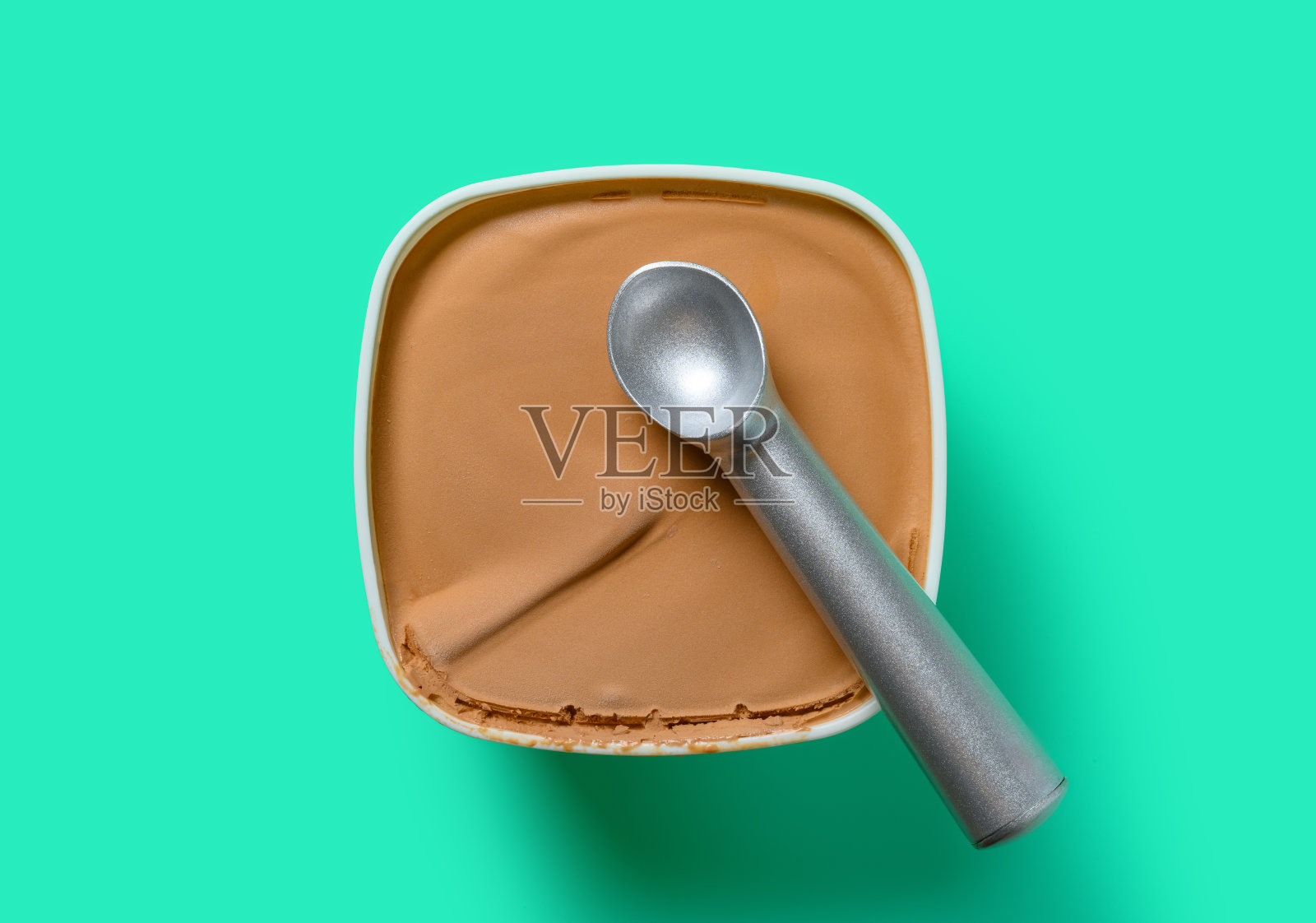 顶视图盒的巧克力口味冰淇淋与一个勺子在一个绿色的背景照片摄影图片