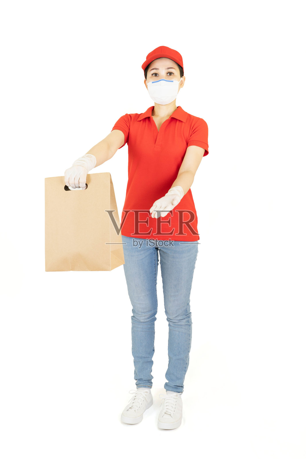 身穿红色制服的亚裔送货女，孤立在白色背景上。快递员带着防护口罩和医用手套送外卖。检疫隔离下的配送服务疾病爆发照片摄影图片