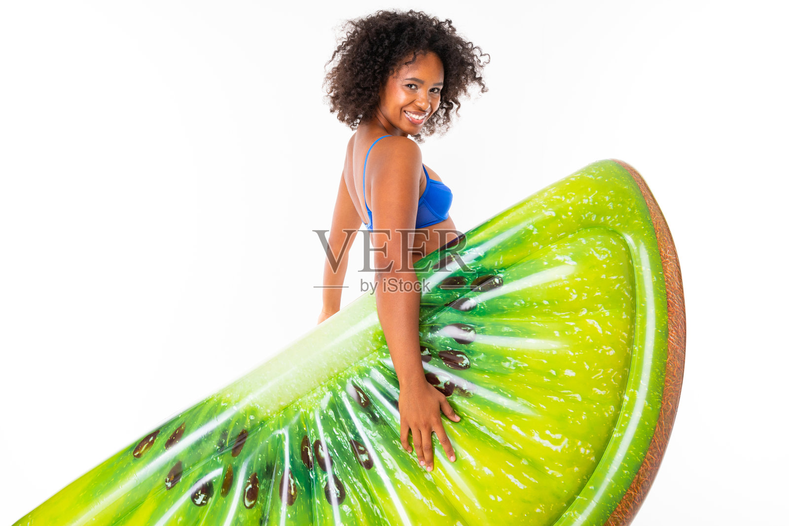 漂亮的非洲女性站在泳衣与橡胶海滩猕猴桃床垫和微笑孤立在白色的背景照片摄影图片