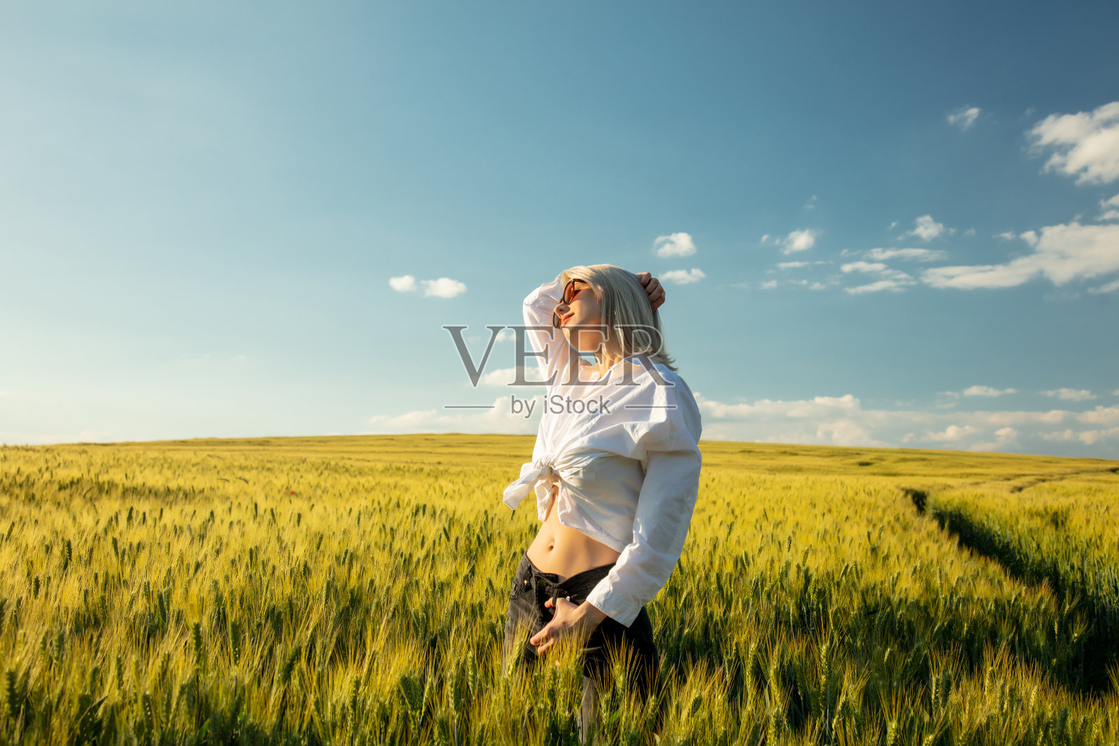 日落时分，麦田里的金发美女照片摄影图片