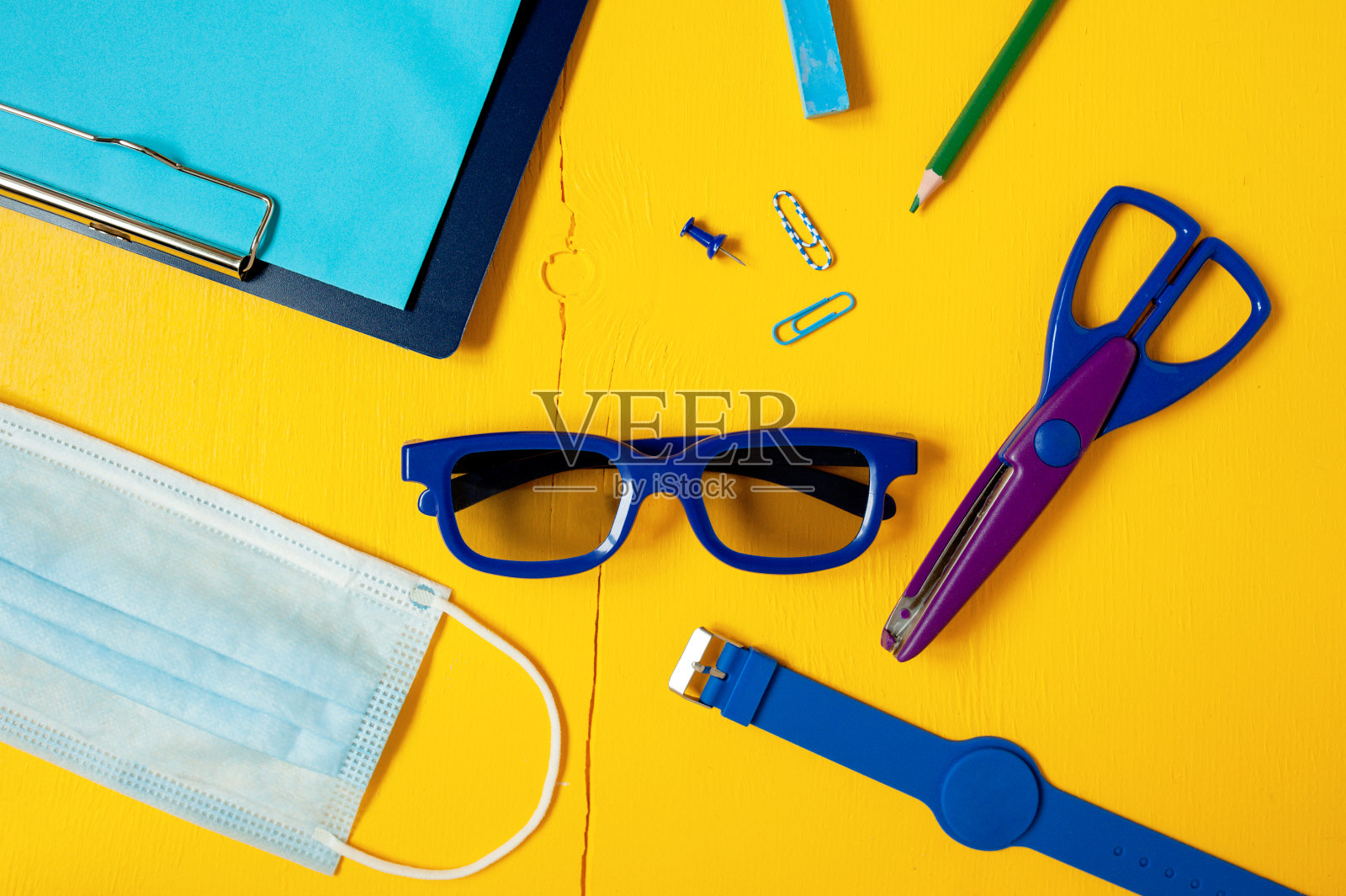 单色配件套装和安全学习配件。塑料蓝眼镜，剪刀，硅胶手表，铅笔，记事本和防护口罩。照片摄影图片