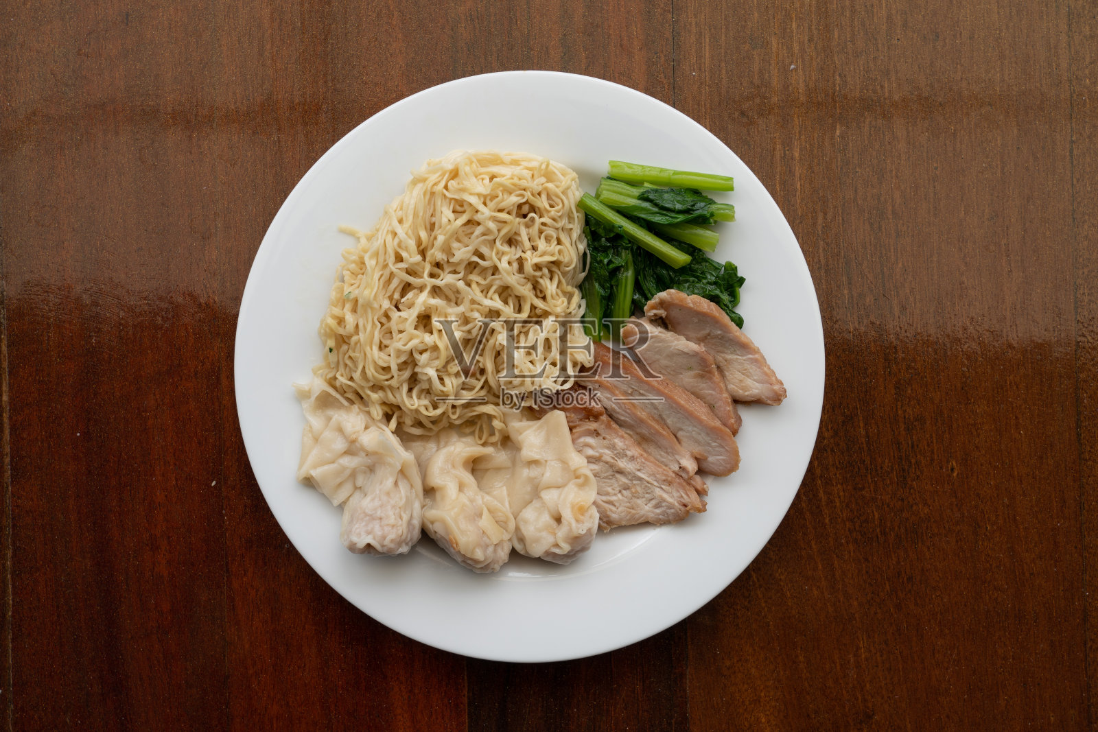 中式蛋面，配红烤猪肉、饺子或馄饨等佐料照片摄影图片