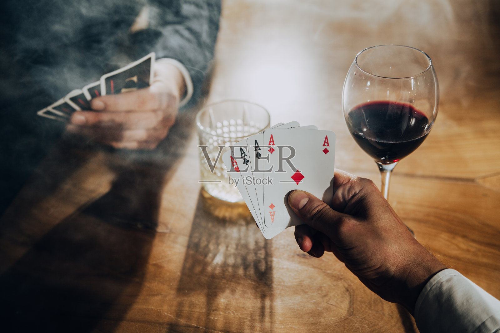男人打牌和喝酒的特写。照片摄影图片