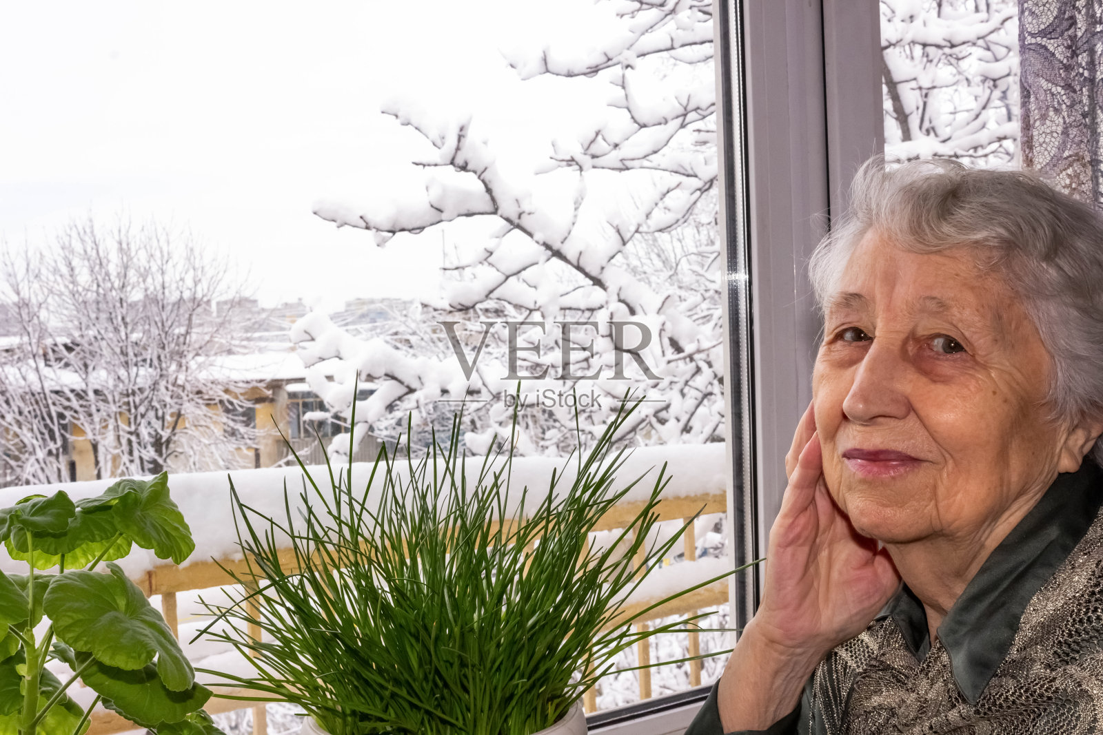 独自坐在房子窗边的老年妇女照片摄影图片