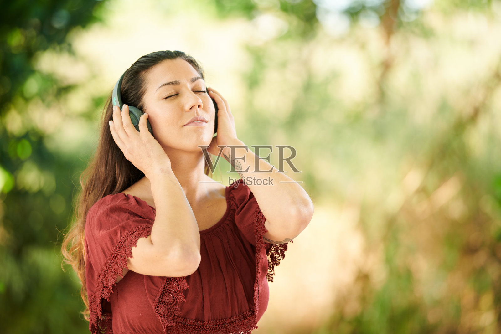 女孩在公园里听轻松的音乐照片摄影图片