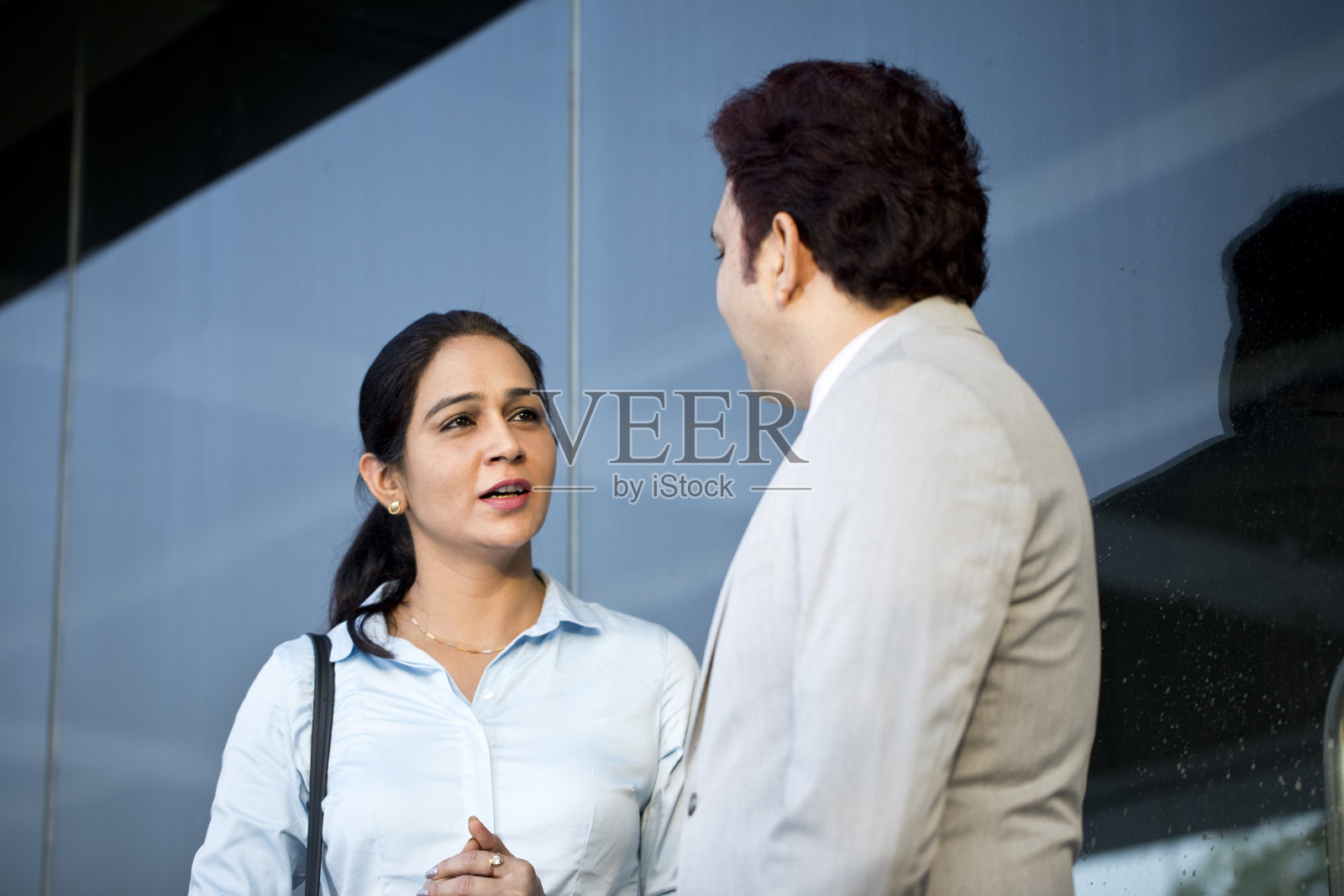 商务同事在办公楼外讨论照片摄影图片