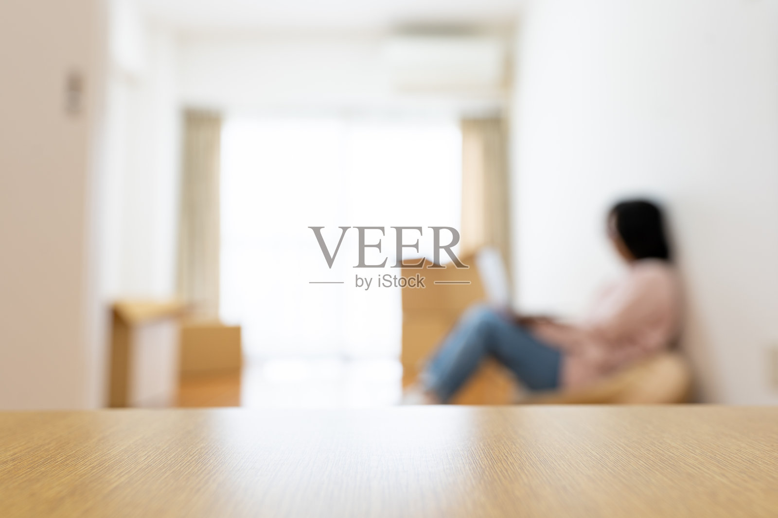 一个女人搬到新公寓检查笔记本电脑，散焦照片摄影图片