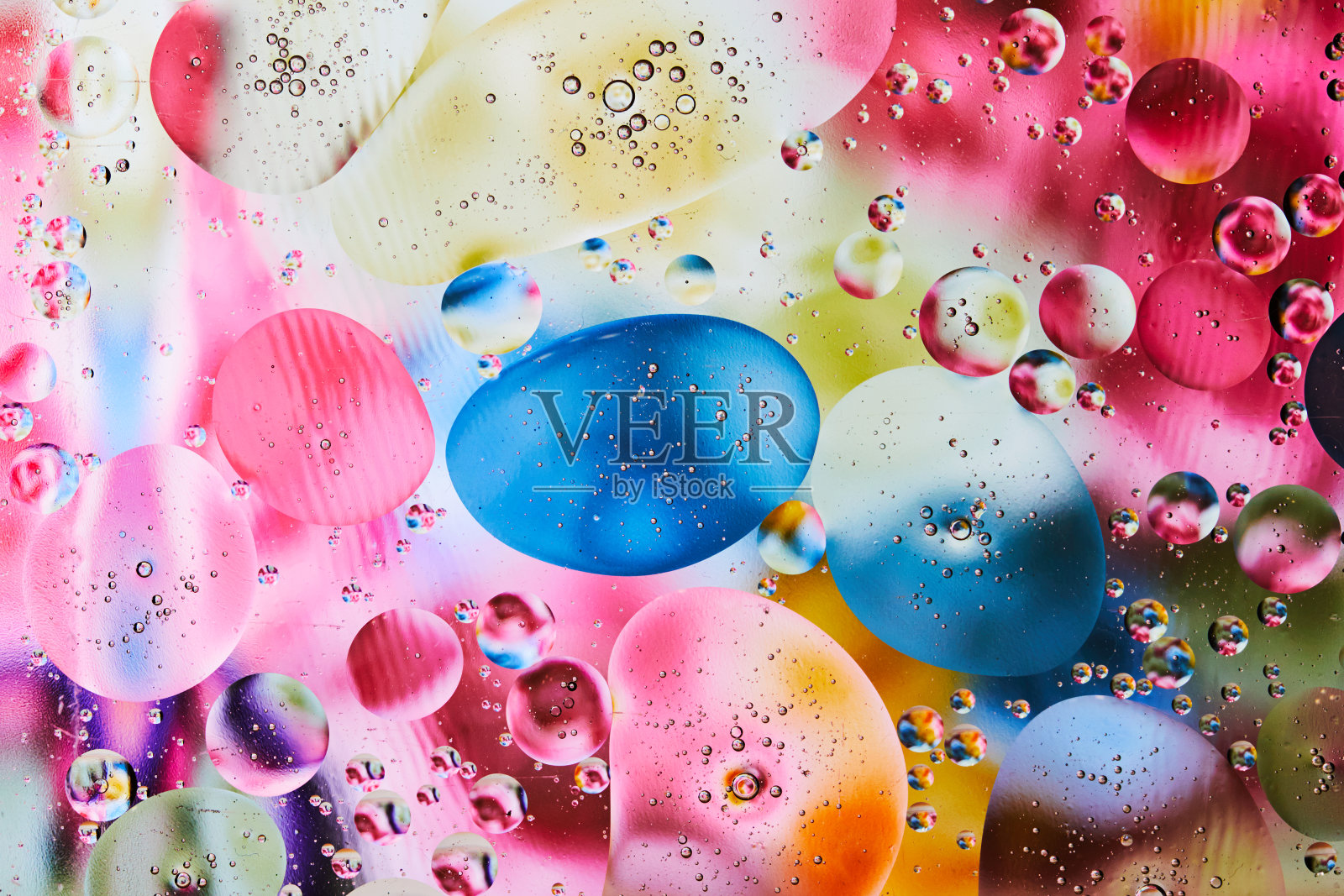 抽象背景与鲜明的颜色。用油滴在水上做实验。近距离观察艺术和彩色的泡泡。空间模式。照片摄影图片