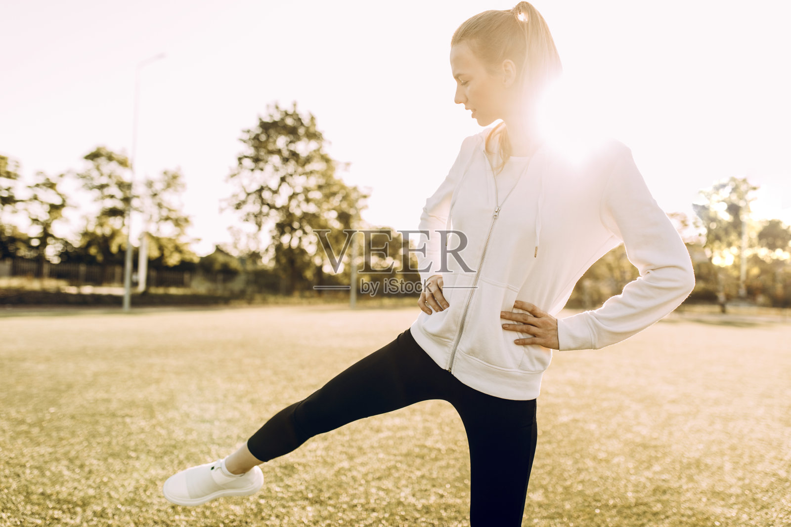 苗条的女孩运动员穿着运动服，在黎明做运动照片摄影图片