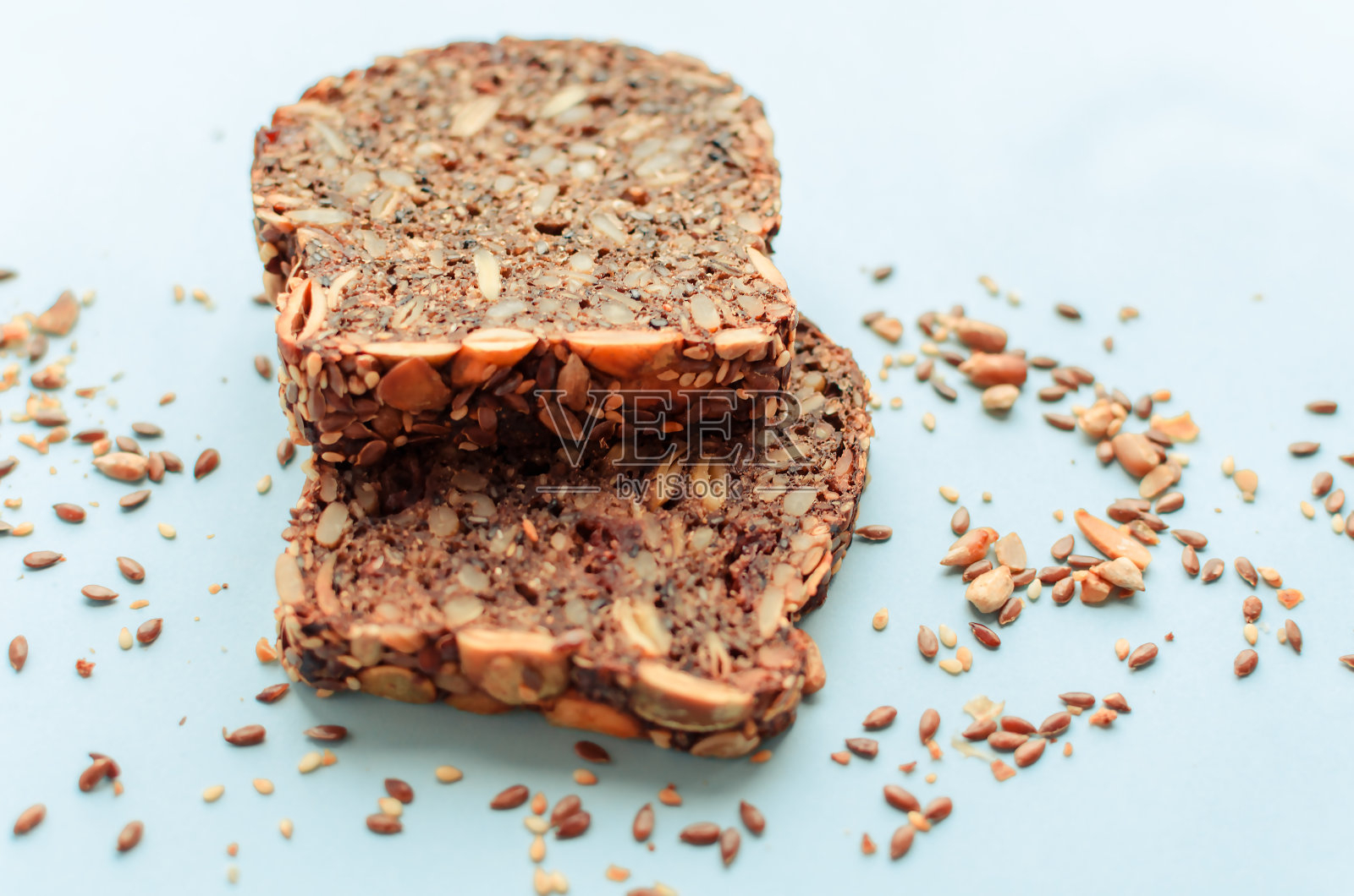 切成薄片的全麦面包，黑麦种子亚麻，向日葵，南瓜和芝麻。健康食品，环保天然产品。粉红色背景上的新鲜面包。照片摄影图片