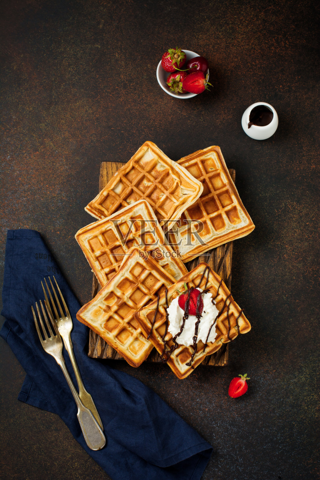 用乳清干酪、巧克力、草莓和樱桃做早餐的自制方形比利时华夫饼。有选择性的重点。前视图。处理空间。照片摄影图片