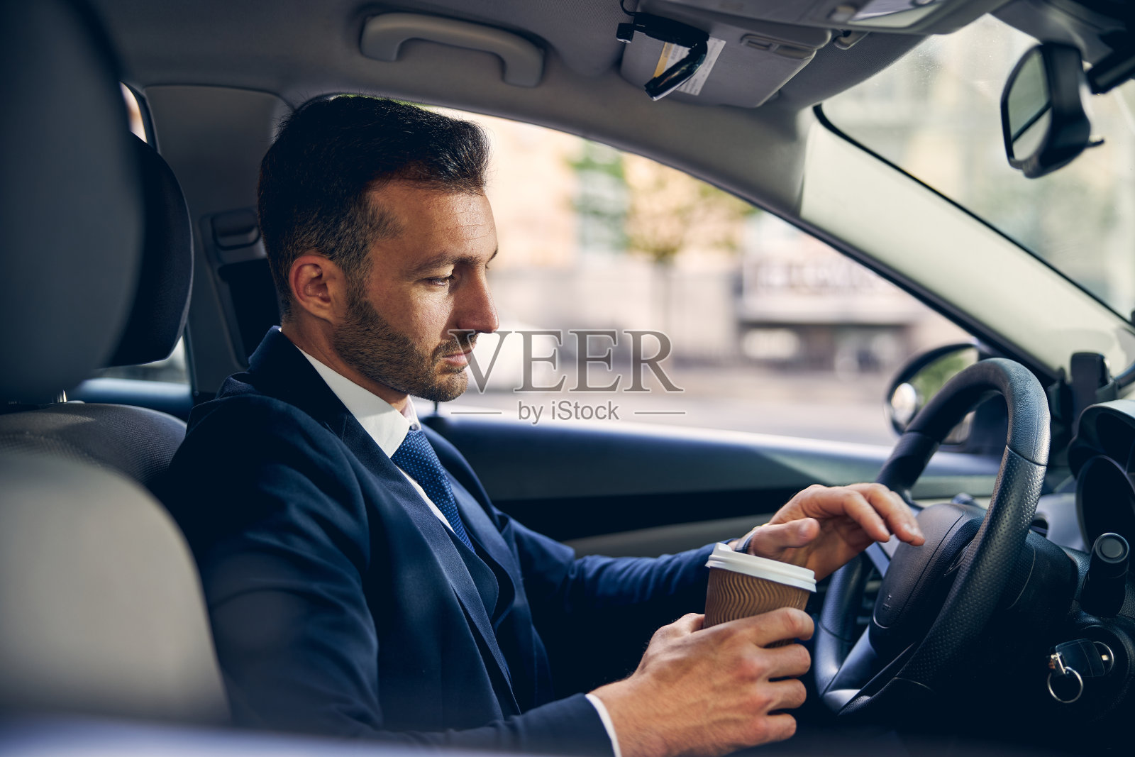 英俊的白人男子在车里喝酒照片摄影图片