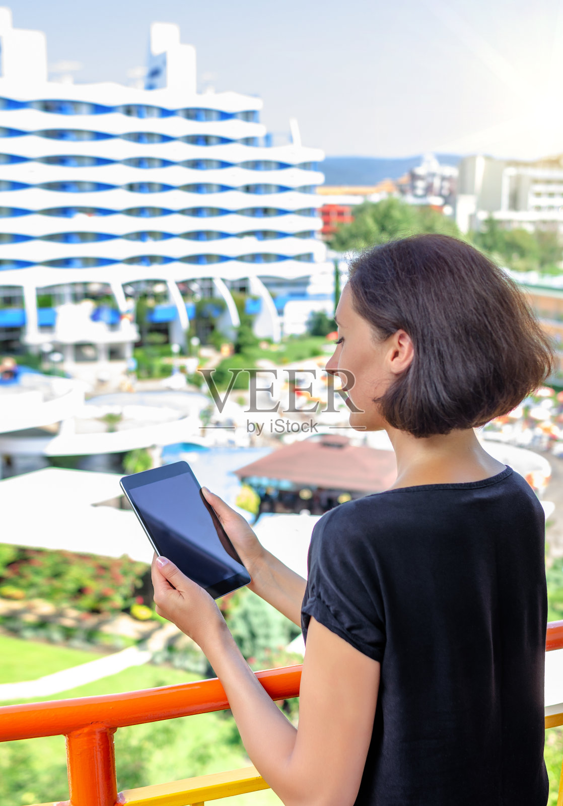 在阳台上用平板电脑看媒体的女人照片摄影图片