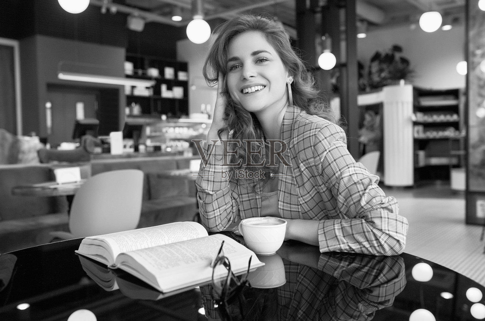 年轻漂亮的女人在咖啡馆喝咖啡和看书照片摄影图片